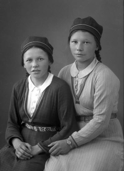 Porträtt av två flickor i samedräkter. Ateljefoto.