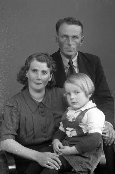 Porträtt av en herre och en dam med ett barn. Ateljefoto.