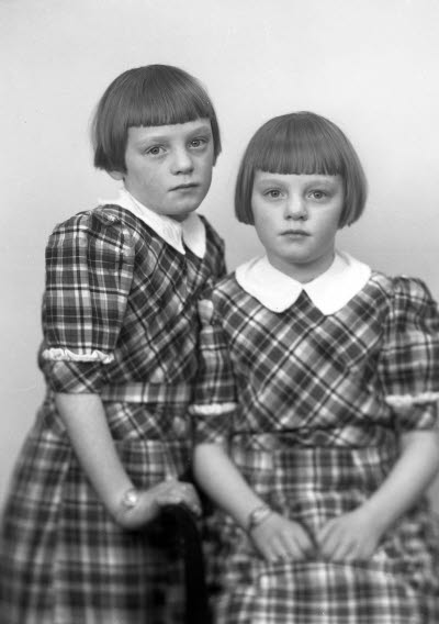 Porträtt av två barn, flickor. Ateljefoto.