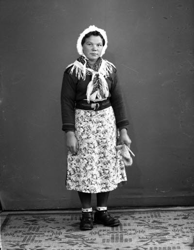 Porträtt av en dam i samedräkt. Ateljefoto.