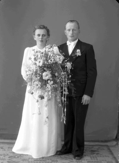 Porträtt av ett brudpar; en herre och en dam. Ateljefoto.