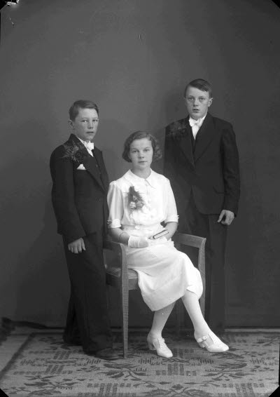 Porträtt av två pojkar och en flicka. Ateljefoto.