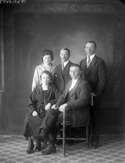 Porträtt av familj, tre herrar, två damer. Ateljefoto.