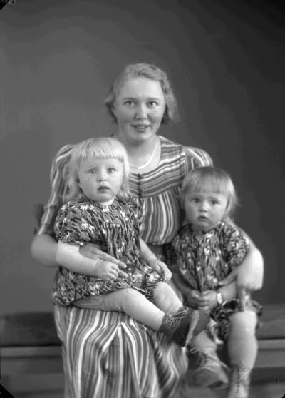 Porträtt av en dam och två barn.