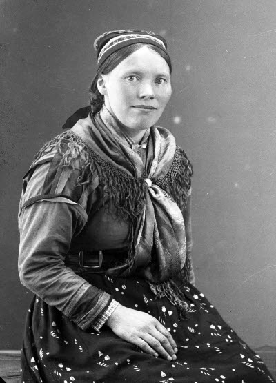 Porträtt av en dam i samedräkt. Ateljefoto.