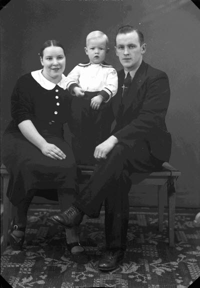 Porträtt av en dam och en herre med ett barn. Ateljefoto.