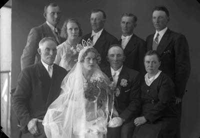 Porträtt av ett brudpar med familj. Ateljefoto.