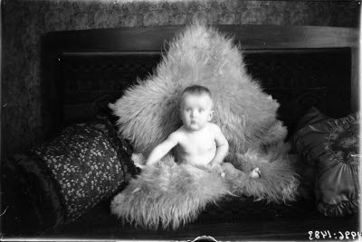 Ett barn på skinnfäll. Hemmiljö.