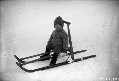 Ett barn på sparksläde.