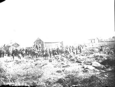 Stor folksamling vid hus; auktion? Kåkrivning?